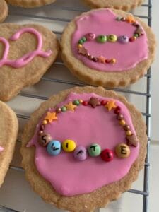 pink cookie with friendship bracelet design spelling 'swiftie'
